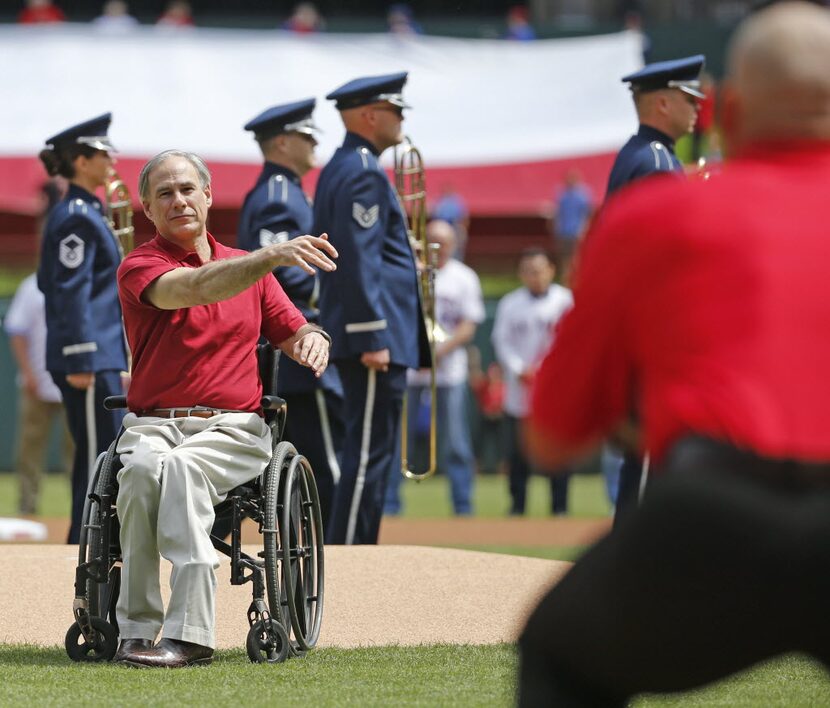 Texas Gov. Greg Abbott throws the "Texas Toss" to former Rangers catcher Ivan "Pudge"...