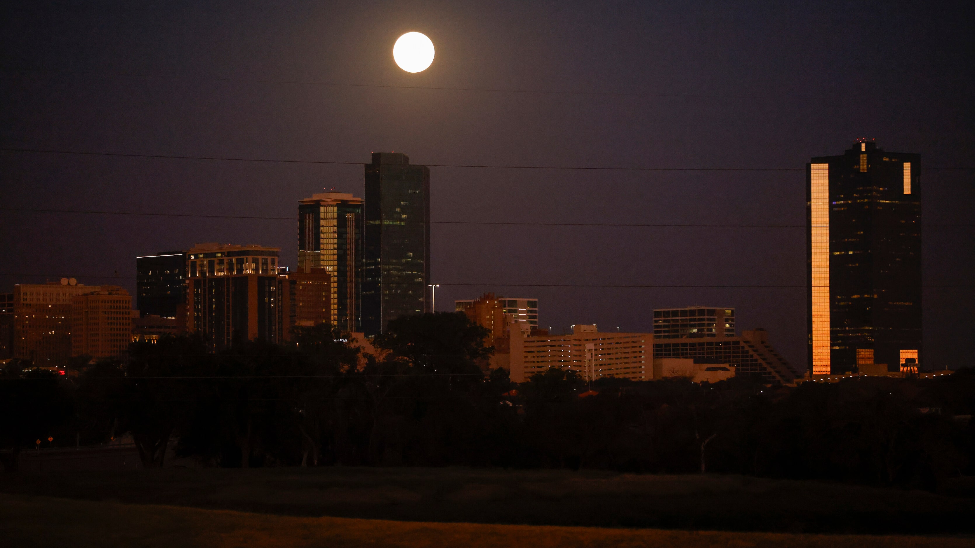 A hunter’s moon sets behind downtown, Thursday, Oct. 17, 2024, in Fort Worth. A hunter’s...