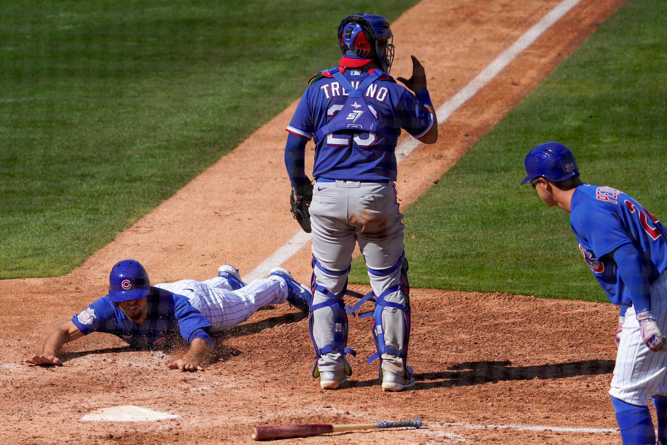 Chicago Cubs third baseman Kris Bryant steals home past Texas Rangers catcher Jose Trevino...