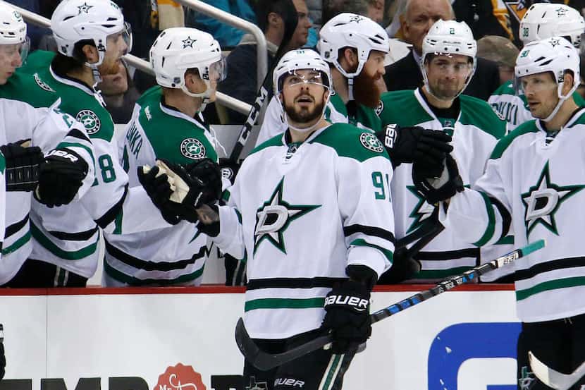 Dallas Stars' Tyler Seguin (91) watches a replay of his goal as he celebrates with teammates...