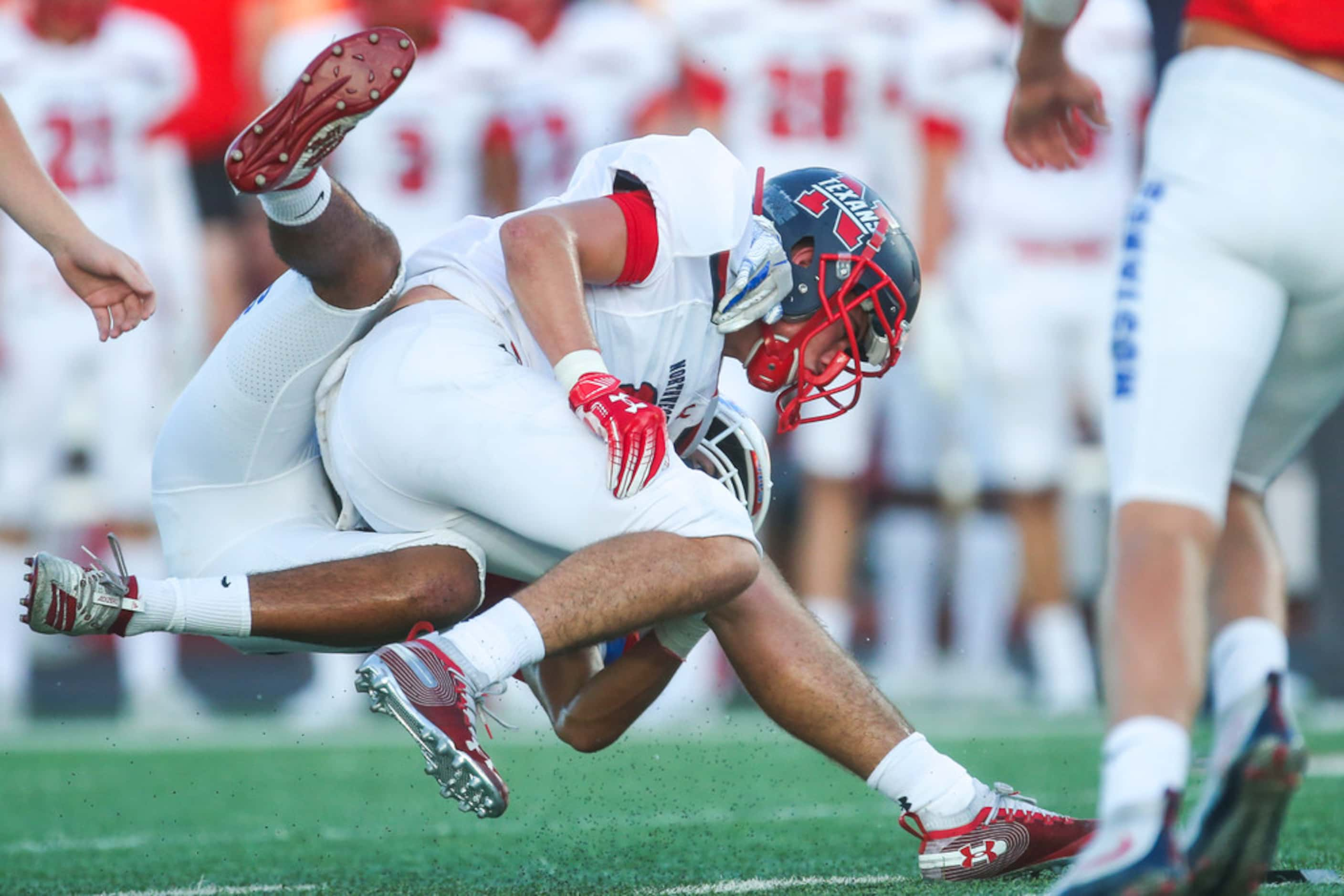 Grapevine defensive back Adriene White (21) brings down Northwest's Weldon Sherrell (6)...