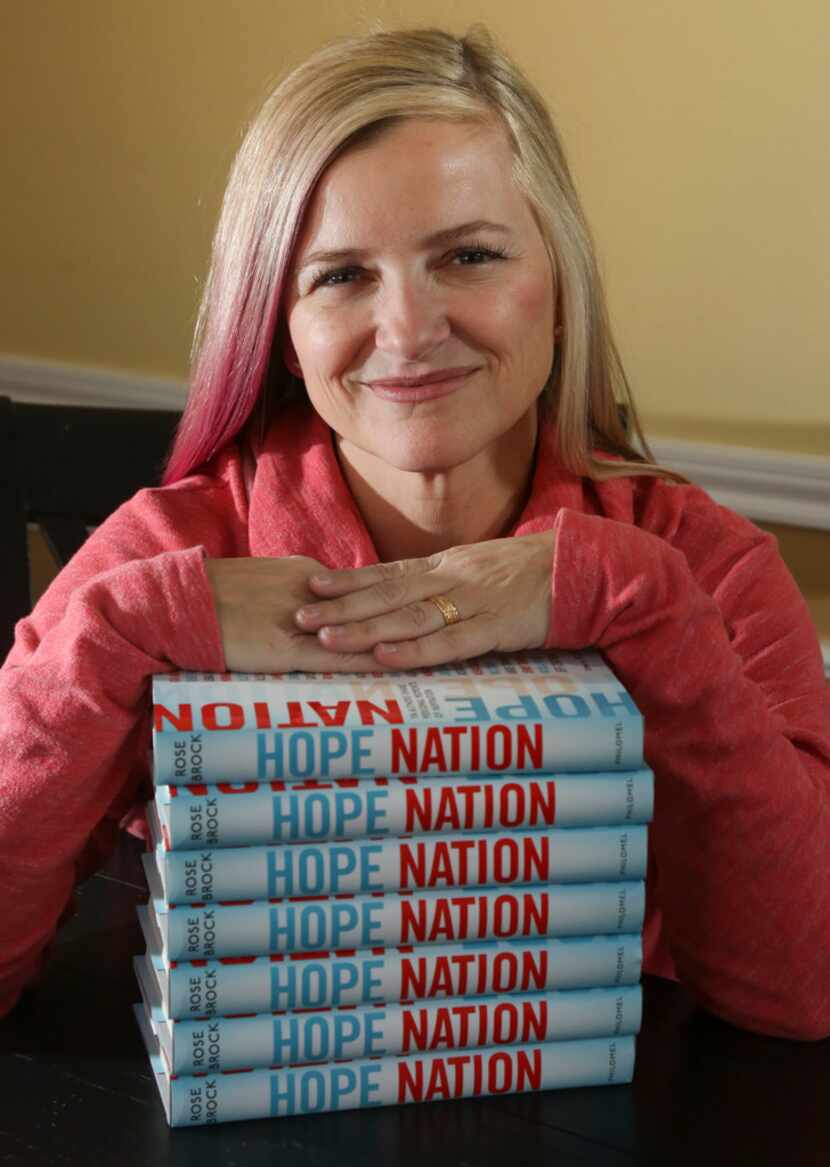 Rose Brock, who is a professor of library science, poses with her new book, 'Hope Nation,'...