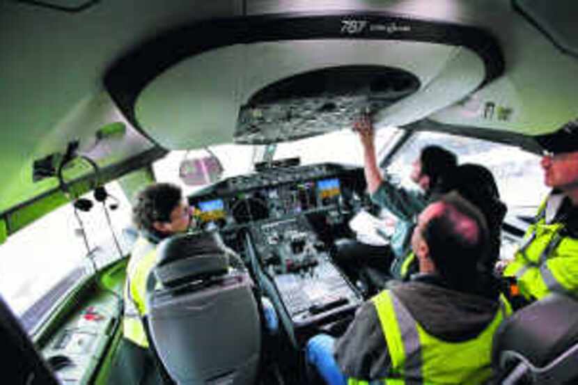  Technicians work in the cockpit of a Boeing 787 at a production plant in Everett, Wash. 
