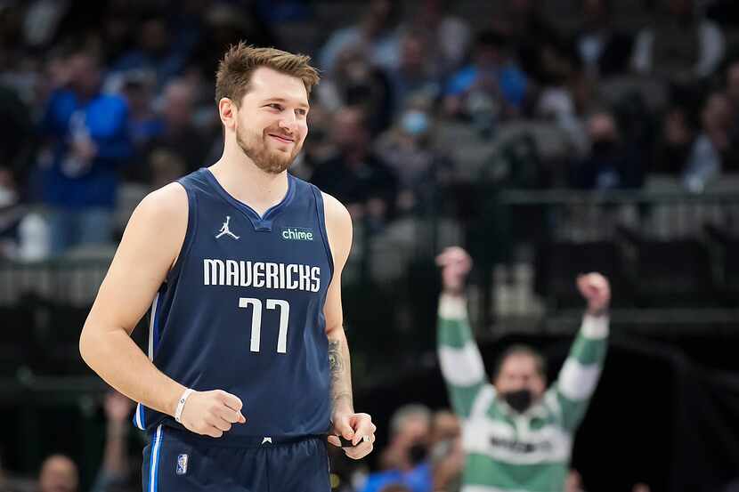 Dallas Mavericks guard Luka Doncic smiles after hitting a 3-pointer on his first shot of the...
