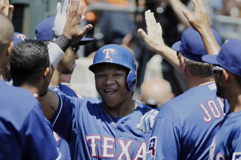 Texas Rangers' Michael Choice is congratulated after hitting a solo home run against the...