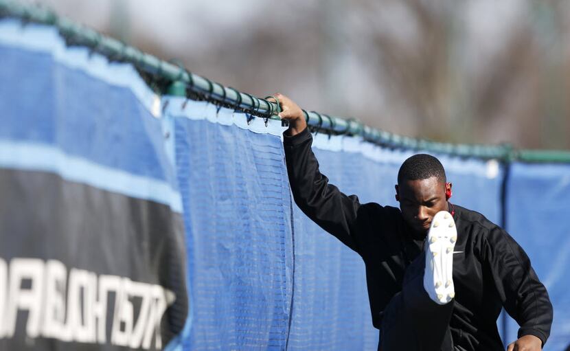 Derrick Kindred stretches his legs before running a timed 40 yard dash during a workout at...