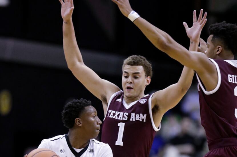 Vanderbilt's Saben Lee (0) is guarded by Texas A&M forward DJ Hogg (1) in the first half of...