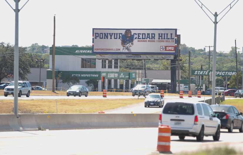 A billboard at the corner of Highway 67 and Red Bird Lane features SMU football player...