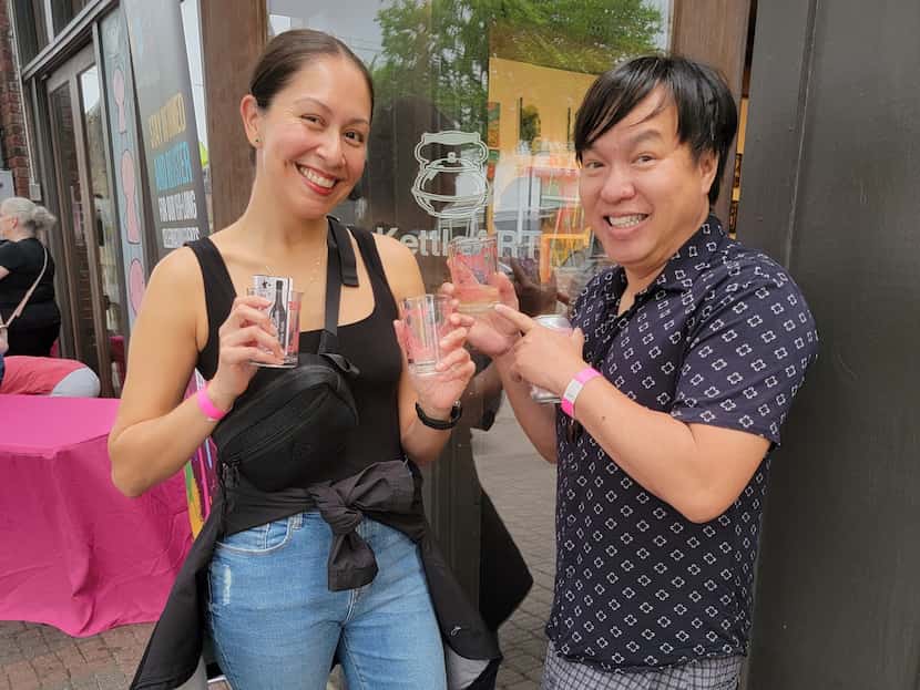 Friends Erica Zavala (left) and Hau Dang (right) pick up their pink drinking glasses...