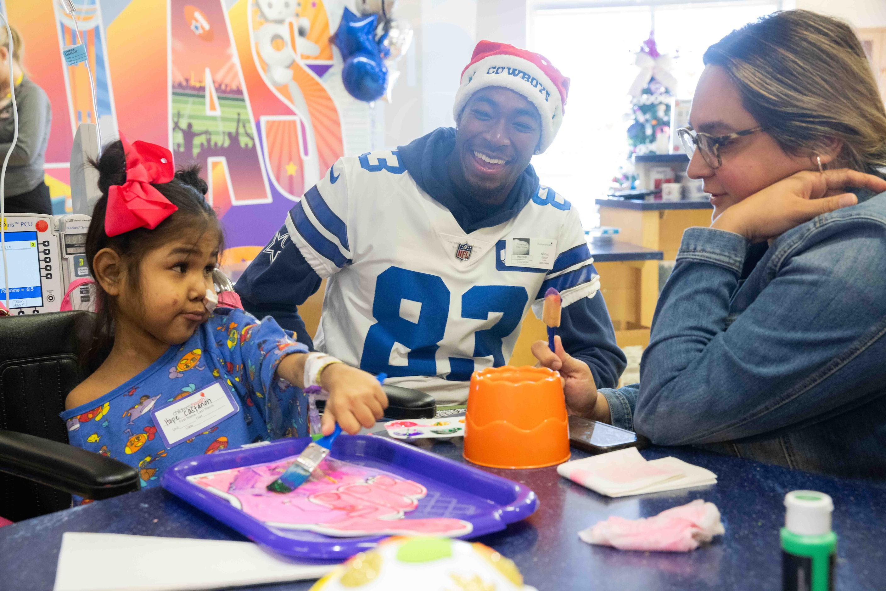 Dallas Cowboys wide receiver Jalen Brooks (83) shares a laugh with Hope Castanon, 7, and her...