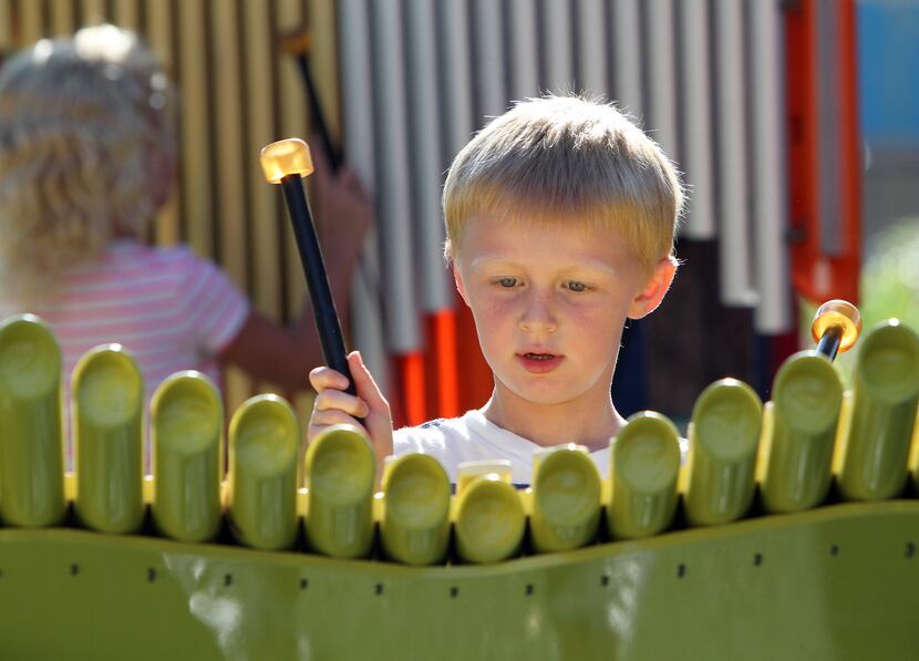 Carter Smith, 5, of Plano, practices his xylophone skills as other children share their...