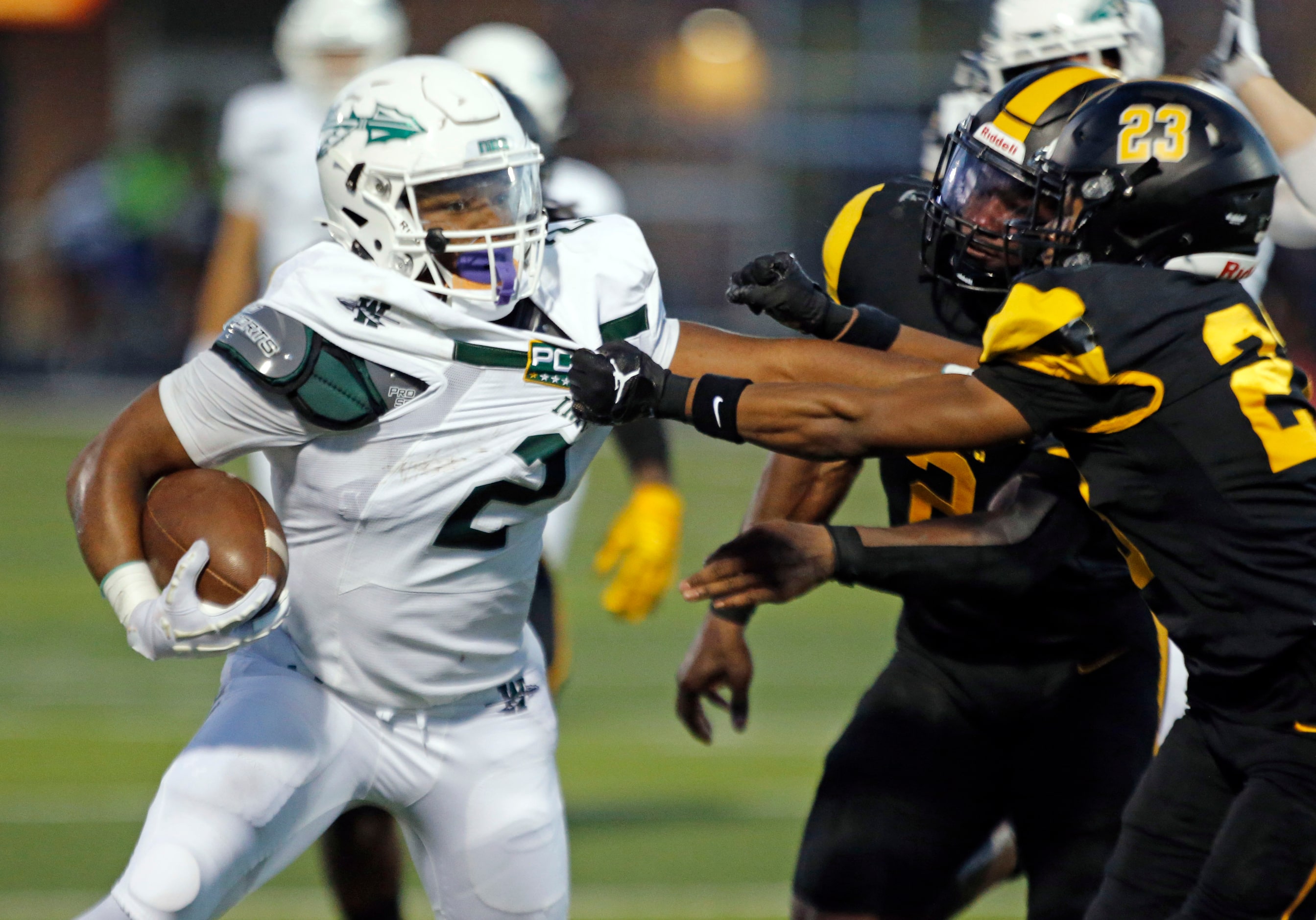 Waxahachie high RB Wade Lemons (2) is tackled by  Forney defender Nolan Williams (23) during...