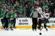 Dallas Stars' Max Domi, left, and Minnesota Wild's Matt Dumba (24) are escorted to the...