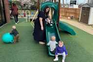 Delaney Griffin, center, plays with toddlers at the child care center where she works in...