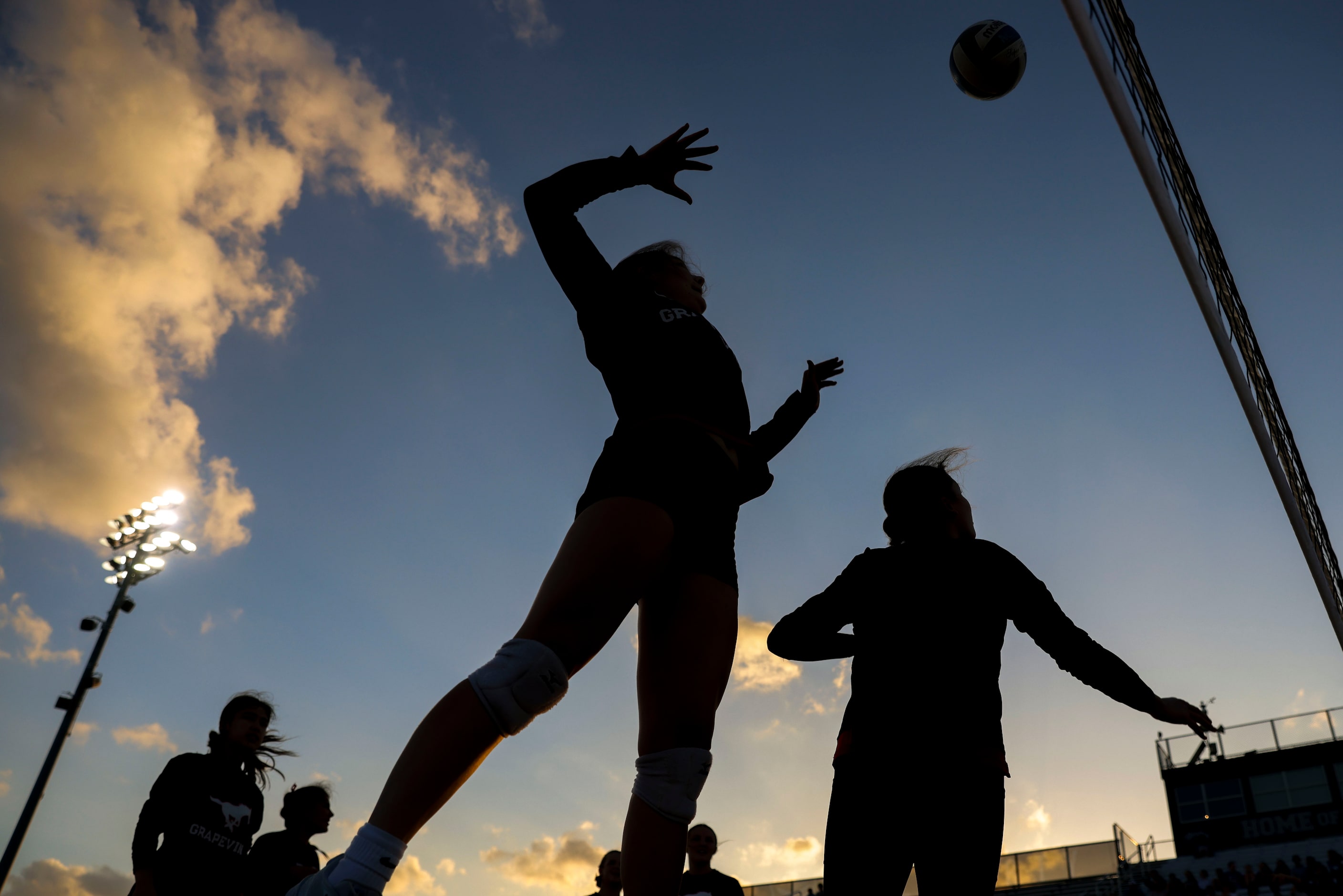 Grapevine High players warm up ahead of an outdoor volleyball game against Liberty Christian...