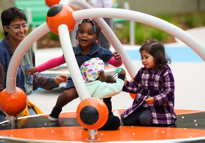 Za’nilah Baker (left), 2, Royal Neal, 1, and Nathaly Galvan (right), 3, take a ride on a...