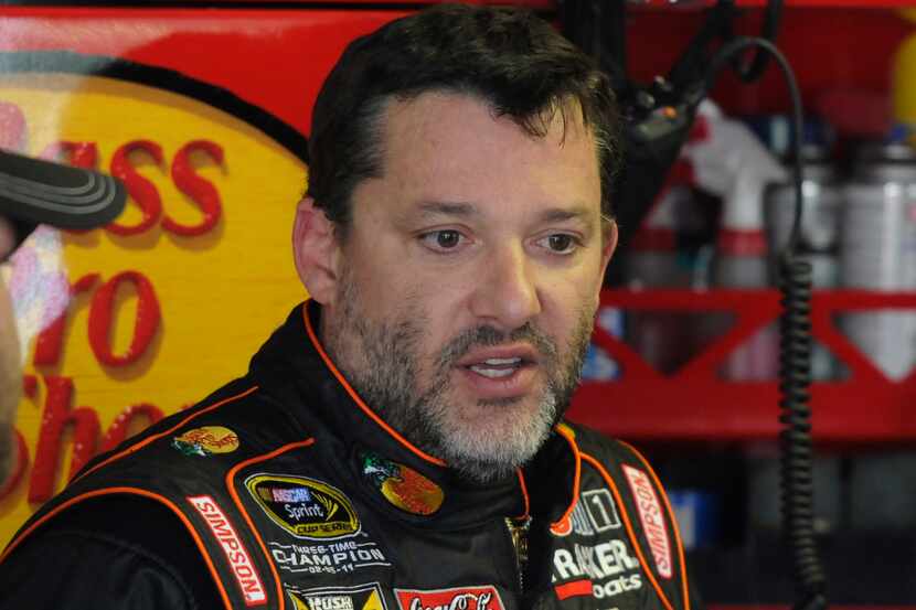 In this April 11, 2014, photo, Tony Stewart stands in the garage during practice for a...