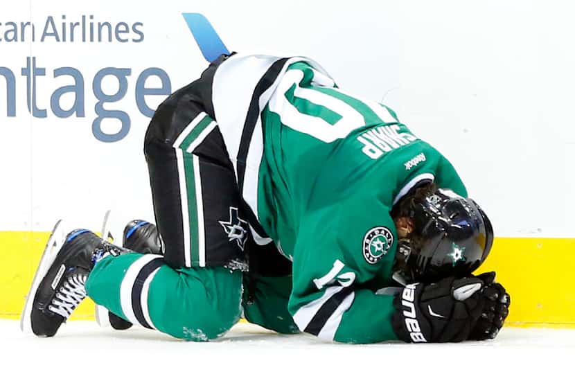 Dallas Stars left wing Patrick Sharp (10) lays on the ice after hitting his head on a check...