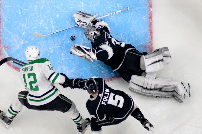 Los Angeles Kings goaltender Jonathan Quick, right, stops a shot by Dallas Stars center...