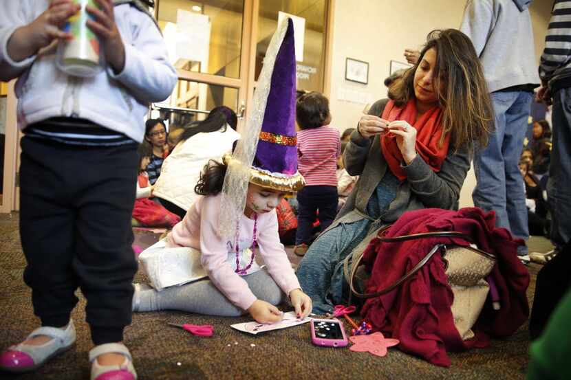 Families create paper masks during the Noon Year's Eve Party for youngsters at the Haggard...
