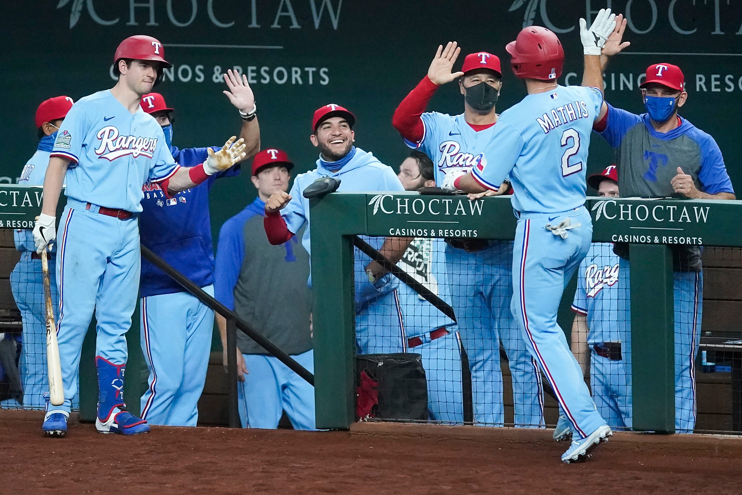 Texas Rangers catcher Jeff Mathis is welcomed back to the dugout by (from left) left fielder...