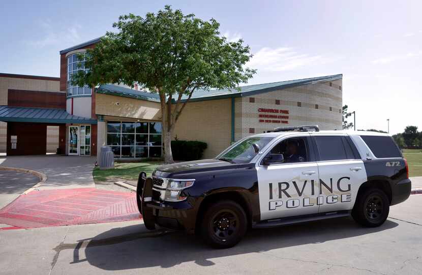 An Irving Police officer idles in front of Cimarron Park Recreation Center in Irving.