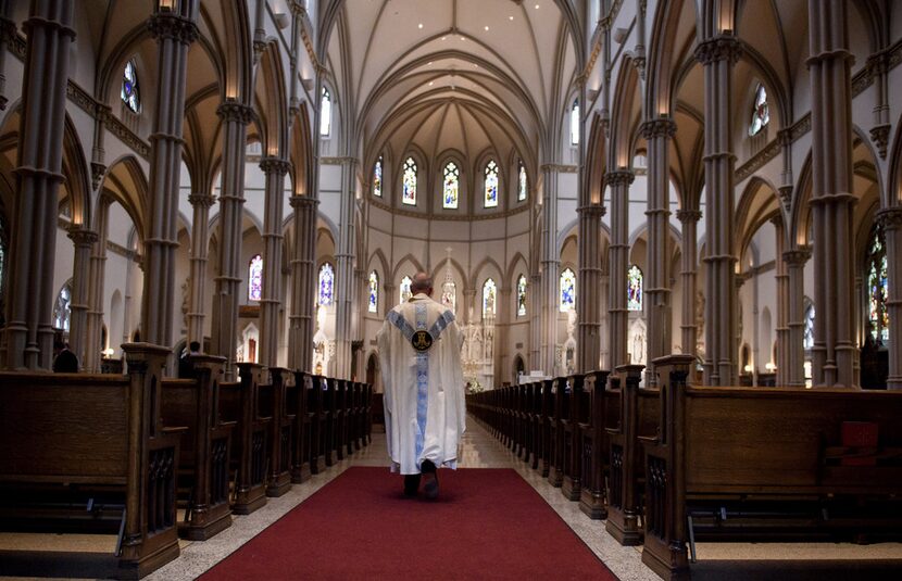 Father Kris Stubna walks through the sanctuary after a recent Mass to celebrate the...