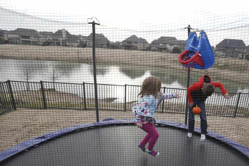 Gavin Woodward, 8 and Riley Woodward, 5, play on the trampoline in the backyard in Frisco on...