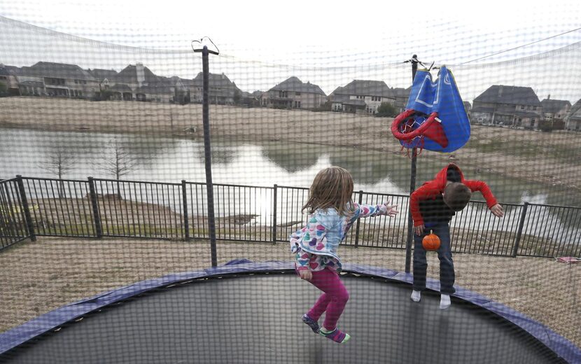 Gavin Woodward, 8 and Riley Woodward, 5, play on the trampoline in the backyard in Frisco on...