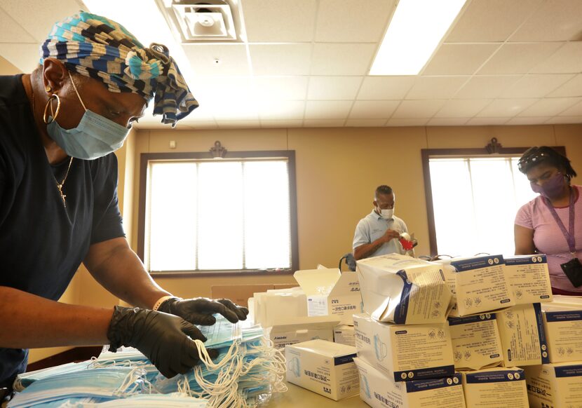 Tonya Royal (left) works with other volunteers on PPE kit assembly.