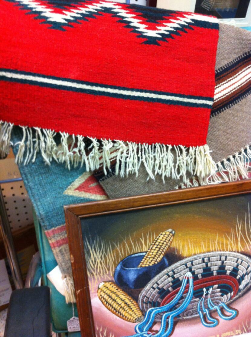 Serapes and vintage Native American-themed paintings hang in Antiques and Things in...