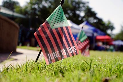 Flags line a sidewalk at the Dallas Juneteenth Festival.