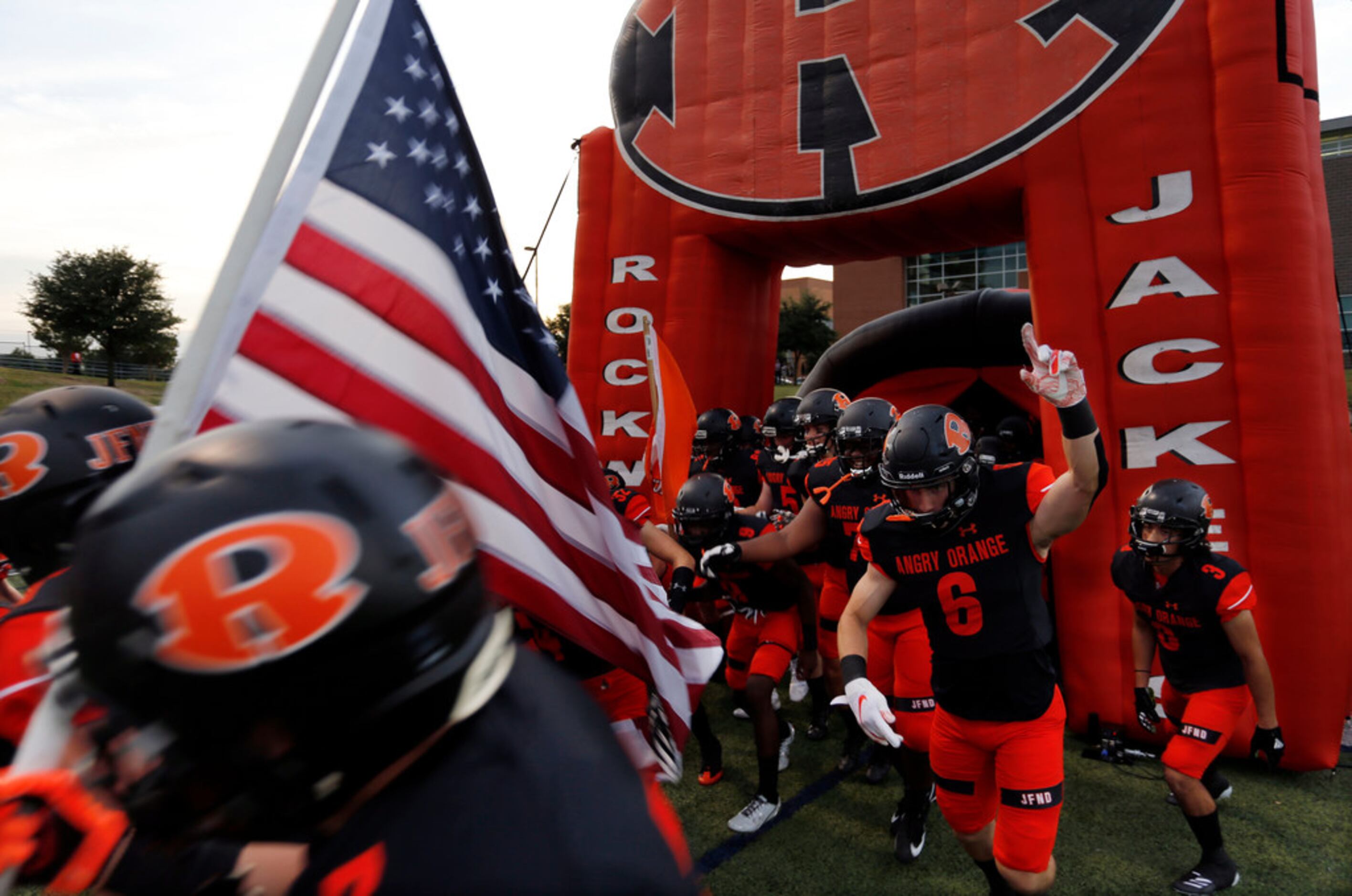 The Rockwall Yellowjackets enter the field before the start of a high school football game...