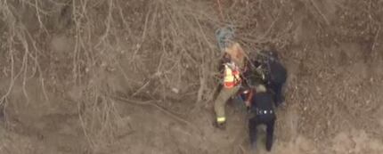 Hutchins firefighters and police, along with Dallas sheriff's deputies, help haul a man up...