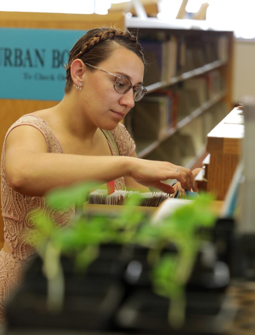 Meara Chadwick thumbs through the new seed library program at the Dallas Public Library...