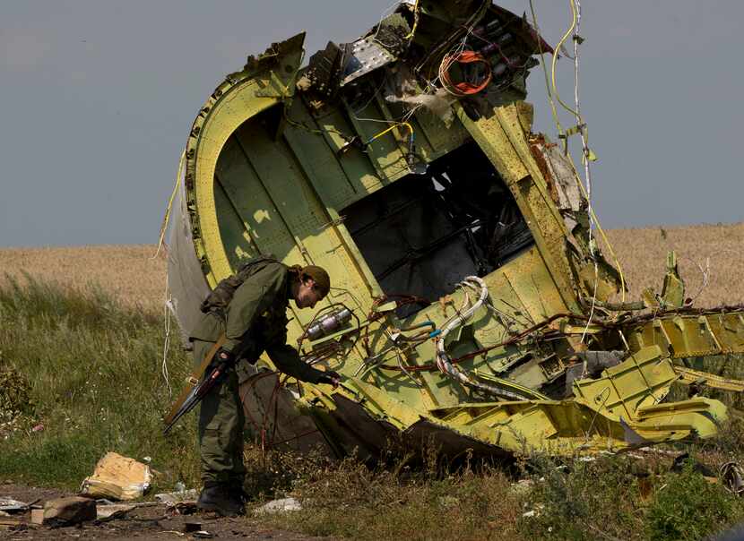 A pro-Russian rebel touches the MH17 wreckage at the crash site of Malaysia Airlines Flight...
