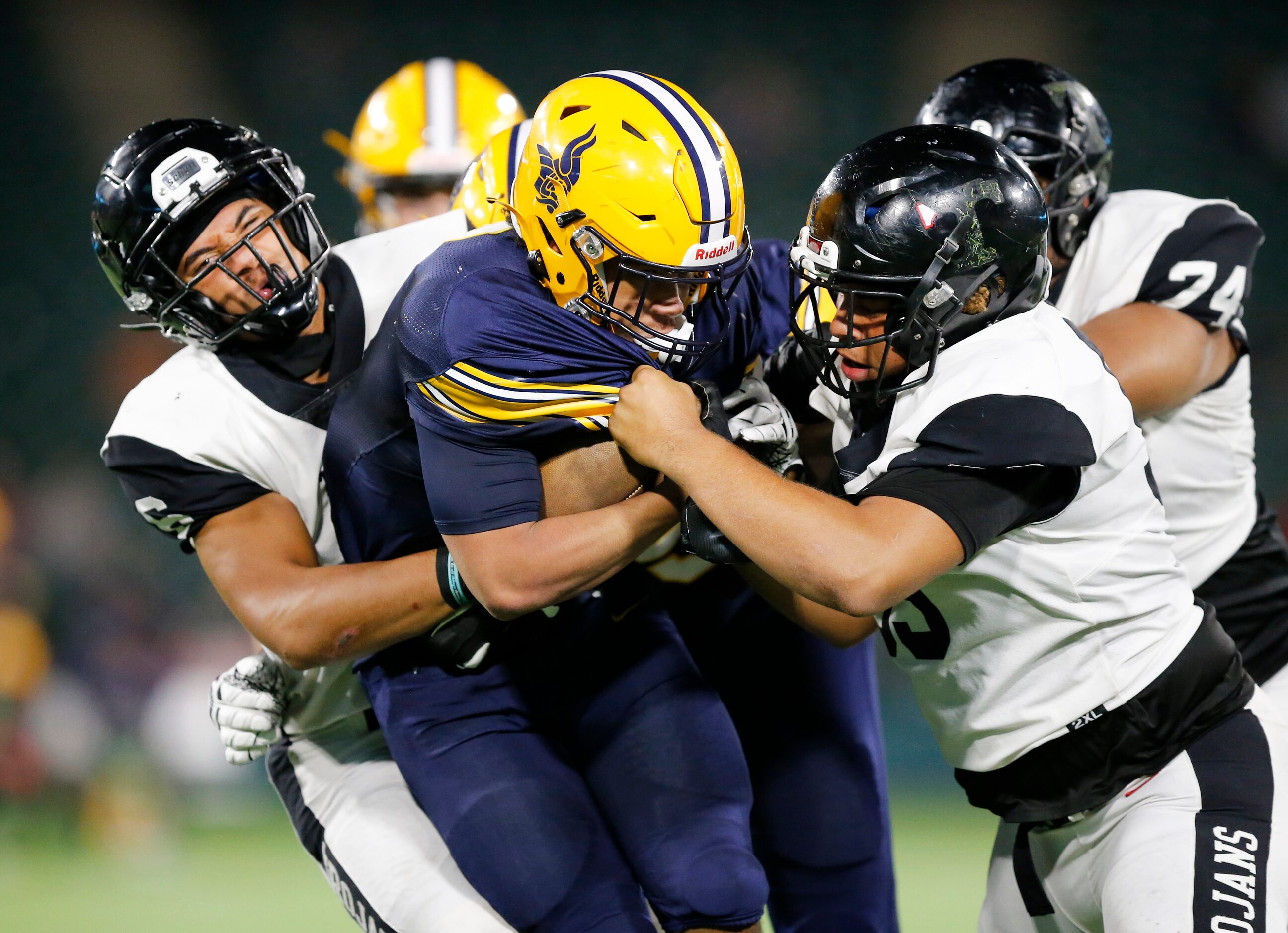 Euless Trinity defenders Nai Mose (left) and Derrold Watkins (right) wrap up Arlington Lamar...