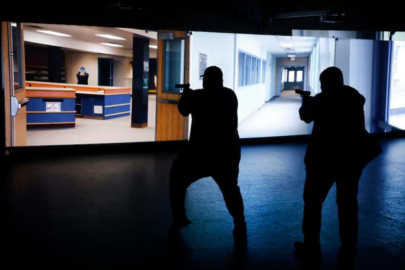 Empleados de una escuela se entrenan con un video ante una situación de tirador activo como...