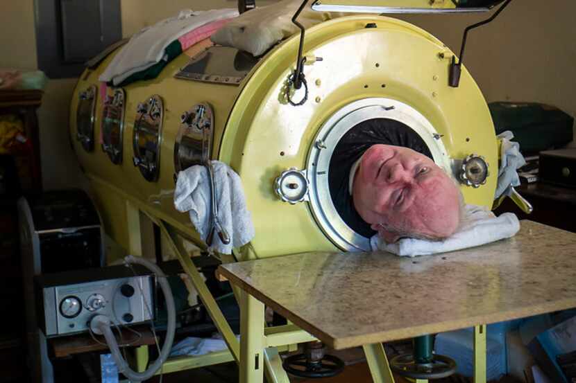 Paul Alexander looks out from inside his iron lung at his home in Dallas.  Now in his 70s,...