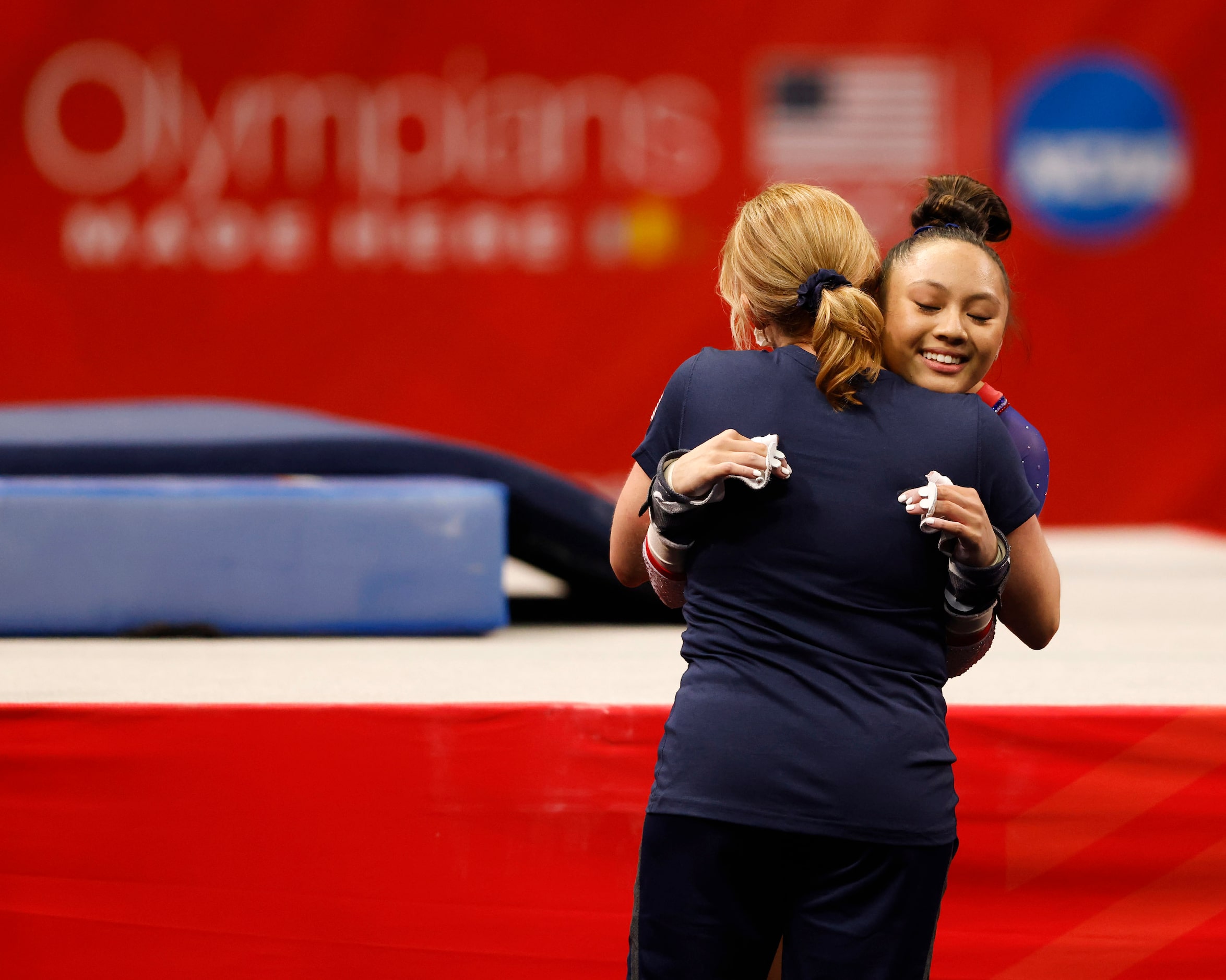 Emma Malabuyo of Texas Dreams hugs her coach Kim Zmeskal after competing in the uneven bars...