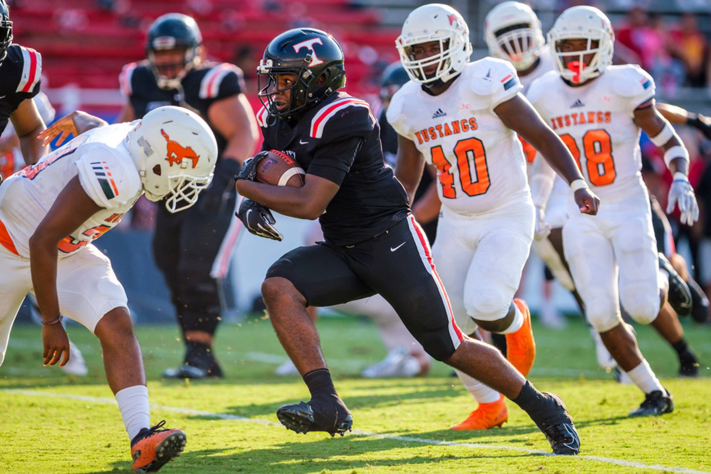 Euless Trinity running back AJ Barnett (5) breaks through the Sachse defense on his way to a...