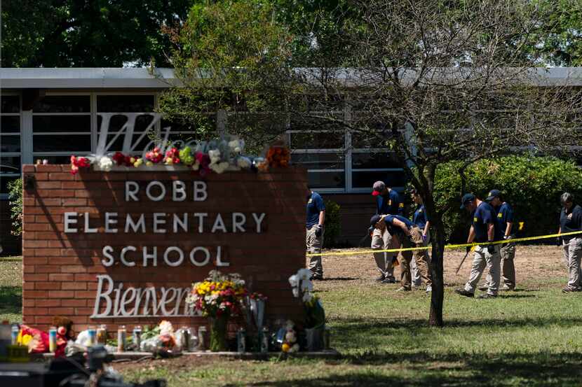 Investigators search for evidence outside Robb Elementary School in Uvalde, Texas,...