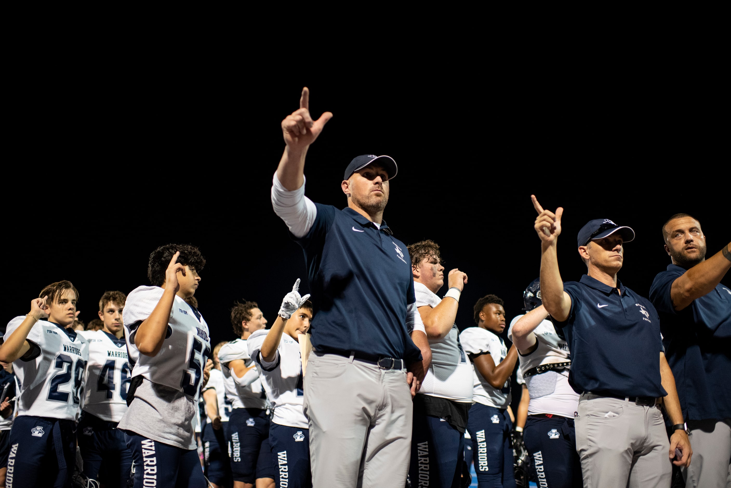 Argyle Liberty Christian Head Coach Jason Witten waves his hand along with the school fight...