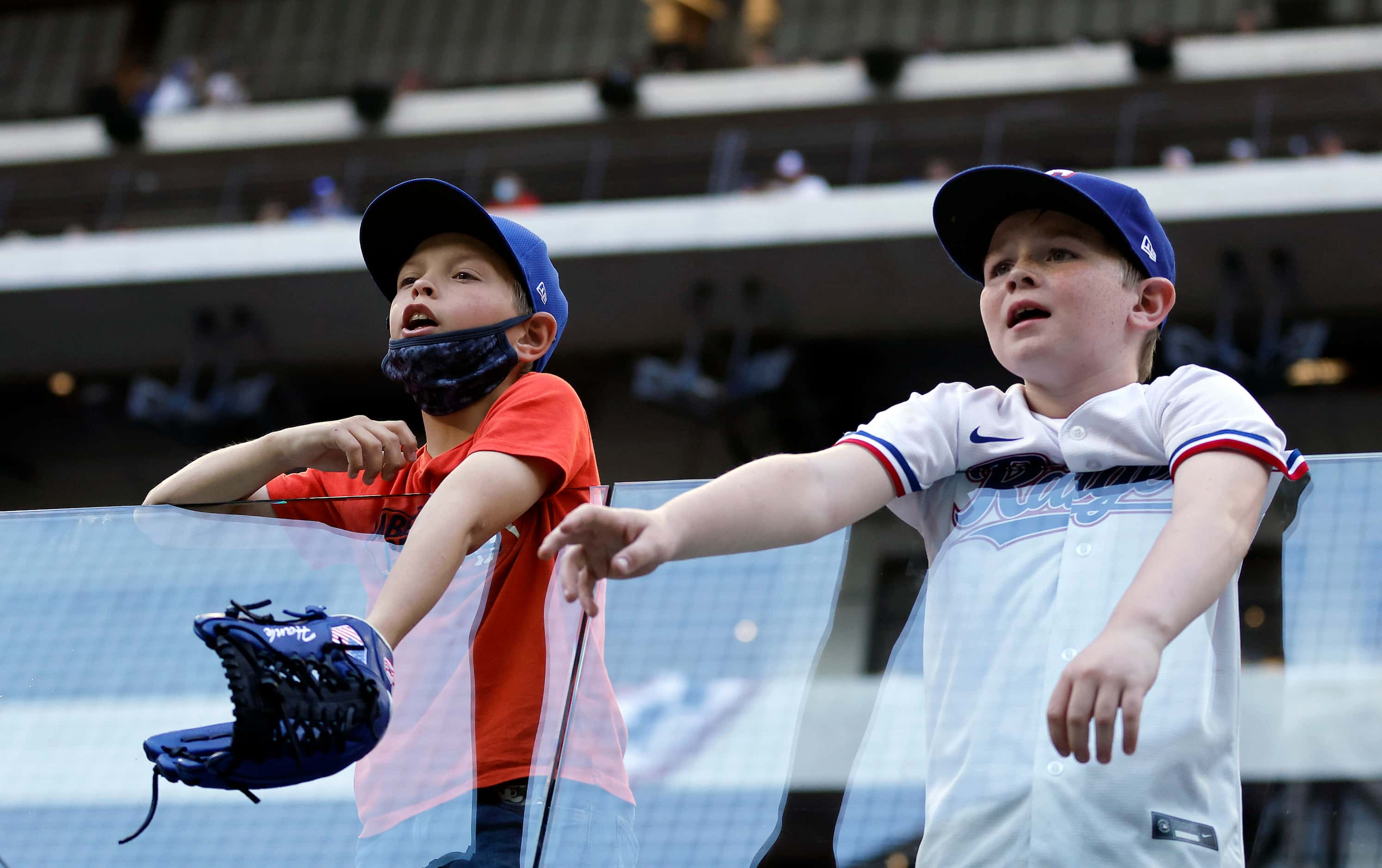 A pair of young Texas Rangers plead for a ball from a Toronto Blue Jays player coming off...