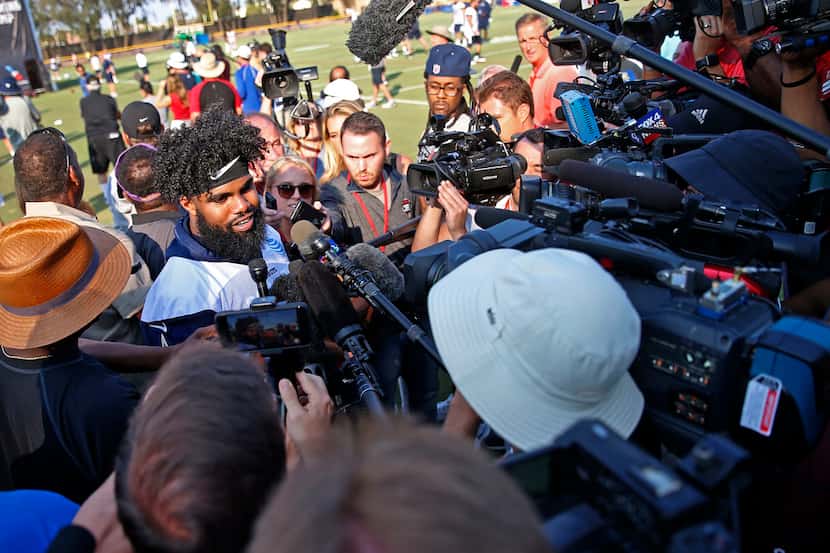 Dallas Cowboys running back Ezekiel Elliott talks with the media after afternoon practice at...