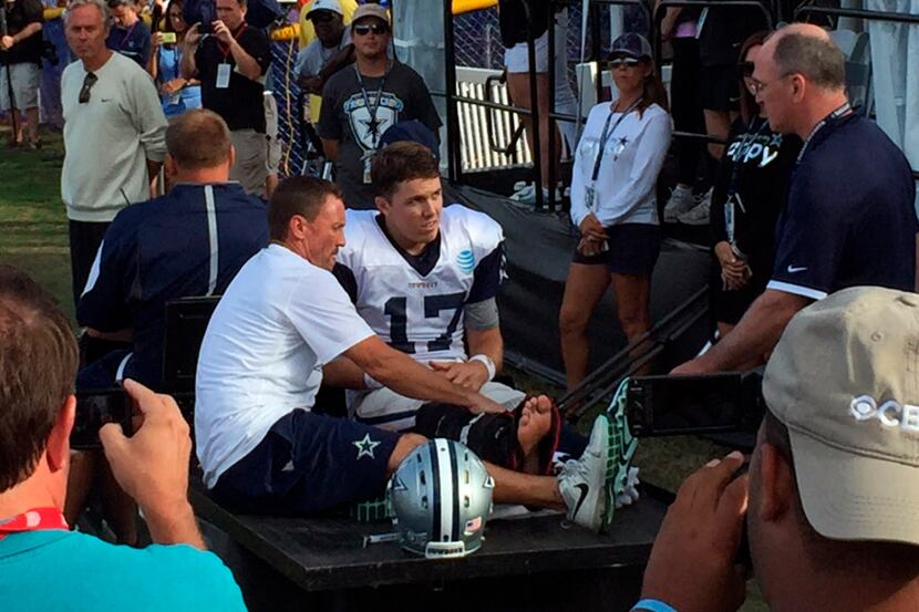 Dallas Cowboys quarterback Kellen Moore (17) listens to the doctor before being carted off...