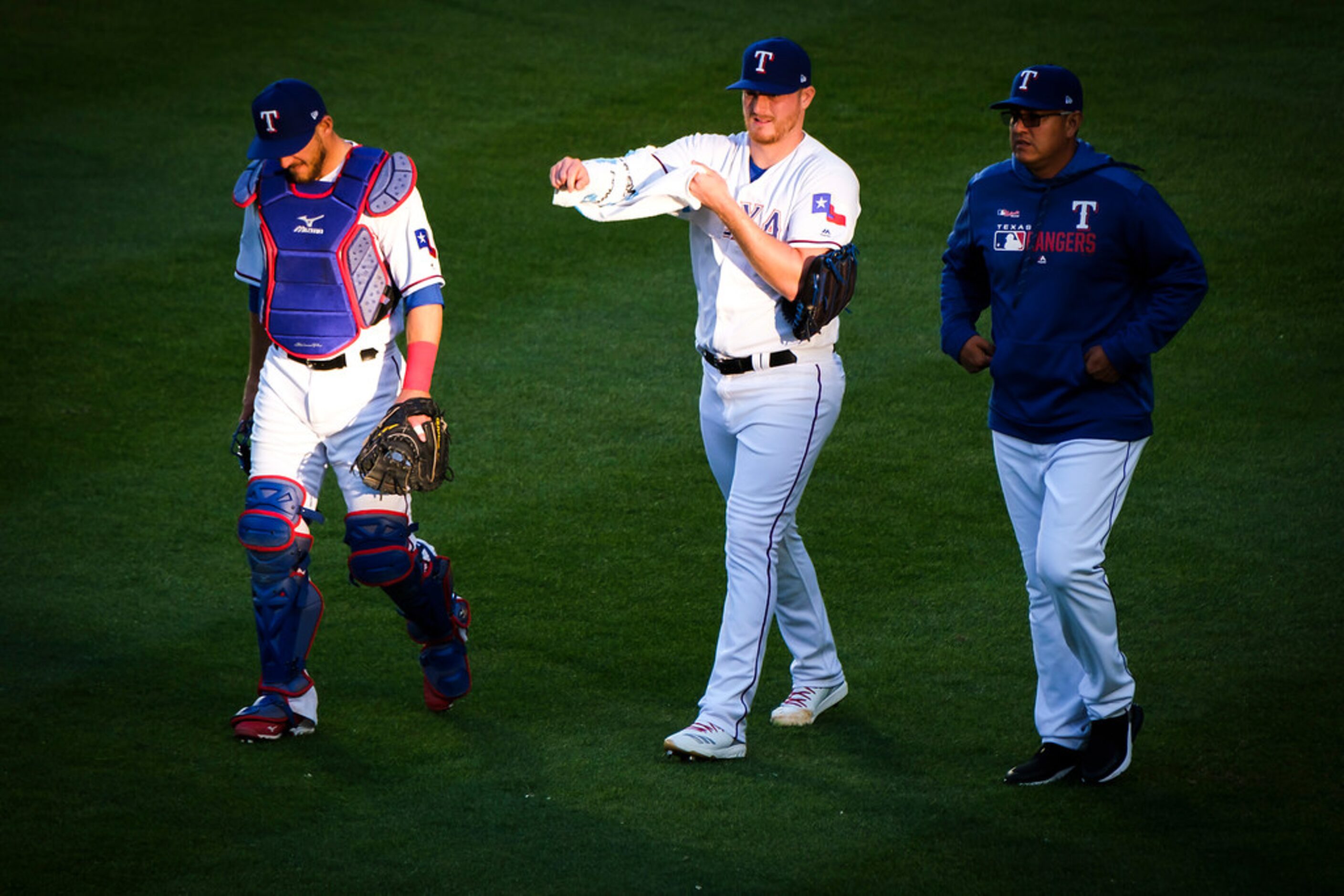 Texas Rangers pitcher Shelby Miller takes the field with catcher Jeff Mathis (left) and...