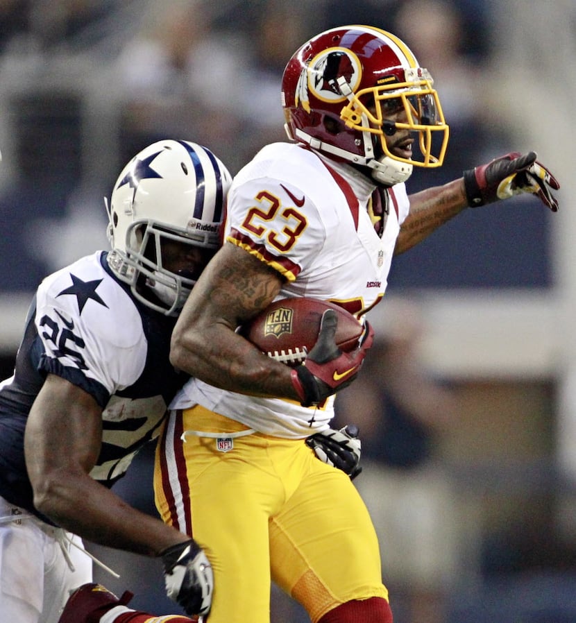 Dallas Cowboys running back Lance Dunbar (25) brings down Washington Redskins cornerback...