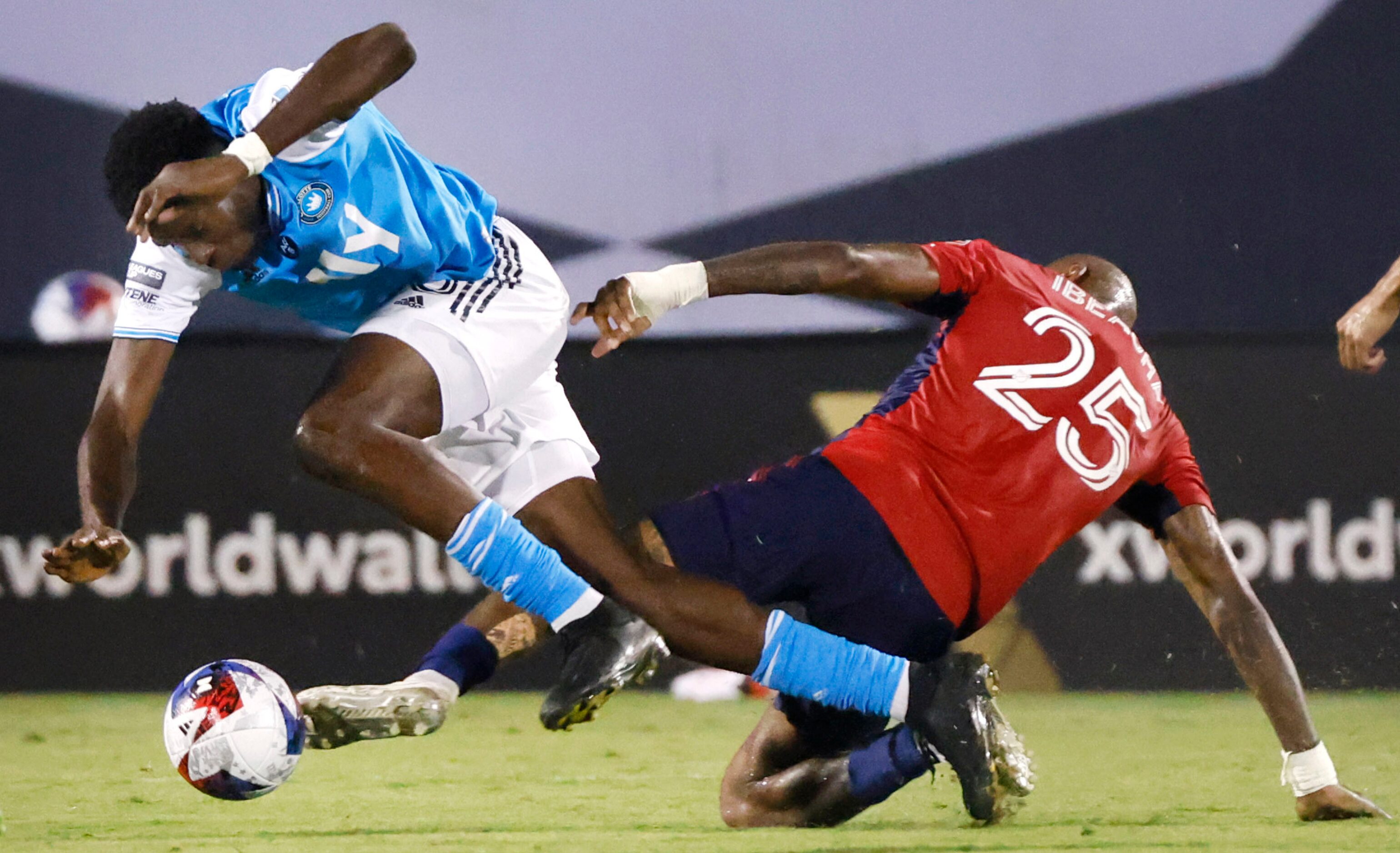 FC Dallas defender Sebastien Ibeagha (25) tackles Charlotte FC midfielder Nick Scardina (35)...