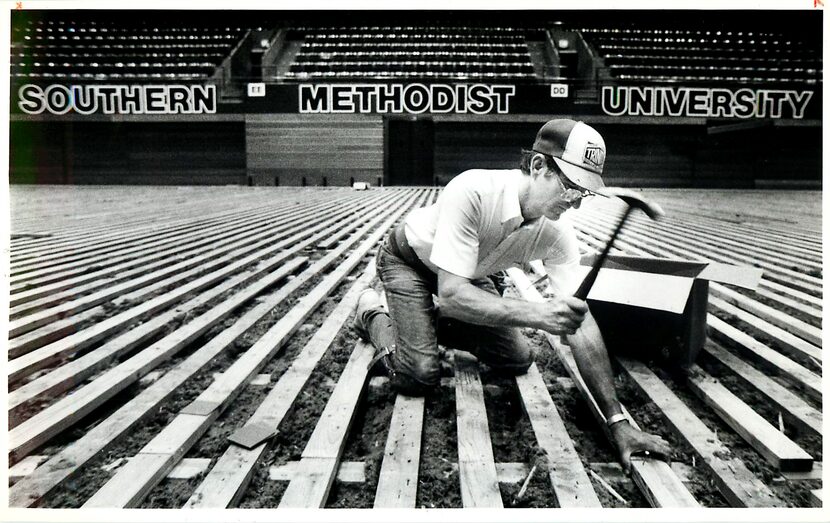 Original caption (revised to add date and city): "Wayne Smith, of Trinity Floor, hammers...